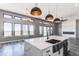 Spacious great room features bright white counters, farmhouse sink, and large windows at 56520 E 74Th Ave, Strasburg, CO 80136
