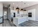 Modern kitchen with white cabinets, quartz countertops, stainless steel appliances, and stylish pendant lighting at 56520 E 74Th Ave, Strasburg, CO 80136