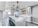 Spacious basement kitchen featuring an island with quartz countertops, white cabinets, and modern lighting at 56520 E 74Th Ave, Strasburg, CO 80136