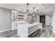 Bright kitchen boasts a quartz island with a sink, stylish pendant lights, and ample counter space at 56520 E 74Th Ave, Strasburg, CO 80136
