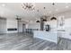 Open-concept living area with kitchen, dining, and fireplace features modern finishes and ample space at 56520 E 74Th Ave, Strasburg, CO 80136