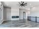 Open living area with fireplace, ceiling fan, and staircase at 56520 E 74Th Ave, Strasburg, CO 80136
