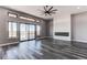 Bright living room with fireplace, contemporary ceiling fan, and sliding glass door to deck at 56520 E 74Th Ave, Strasburg, CO 80136