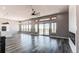 Open-concept living room with large windows, hardwood floors, and a modern fireplace at 56520 E 74Th Ave, Strasburg, CO 80136