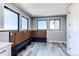 Convenient mud room with wood slat accent wall, built-in bench, coat hooks, and stylish gray flooring at 56520 E 74Th Ave, Strasburg, CO 80136