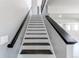 Elegant staircase featuring white risers and dark wood treads, leading to the upper level of the home at 56520 E 74Th Ave, Strasburg, CO 80136