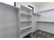 Spacious walk-in closet featuring built-in shelving, hanging rods, and neutral carpeting at 56520 E 74Th Ave, Strasburg, CO 80136