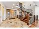 Grand entryway with a curved wooden staircase and stone flooring at 127 Windwood Cir, Breckenridge, CO 80424