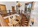 Grand curved staircase with wooden railing and chandelier at 127 Windwood Cir, Breckenridge, CO 80424