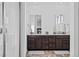 Bright bathroom features a dual vanity with dark wood cabinets, tile flooring, and a shower with glass doors at 15606 W Girard Ave, Morrison, CO 80465
