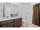 Bathroom featuring a dual vanity, marble countertops, a soaking tub with shower, and modern fixtures at 15606 W Girard Ave, Morrison, CO 80465