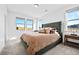 Bright bedroom features plush carpet, large windows, and an inviting bed with colorful pillows and coverlet at 15606 W Girard Ave, Morrison, CO 80465