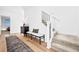 Well-lit entryway features a decorative rug, hall table, and staircase with modern black metal spindles at 15606 W Girard Ave, Morrison, CO 80465