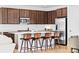 Modern kitchen featuring dark wood cabinets, stainless steel appliances, and a large island with barstool seating at 15606 W Girard Ave, Morrison, CO 80465