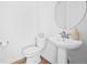 Bright powder room featuring a white toilet and pedestal sink, perfect for guests at 15606 W Girard Ave, Morrison, CO 80465