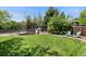 Green backyard with trampoline, play set, and a relaxing seating area to enjoy the outdoors at 13390 W Warren Ave, Lakewood, CO 80228