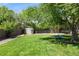 View of the well-manicured lawn, mature trees and a shed for outdoor storage at 13390 W Warren Ave, Lakewood, CO 80228
