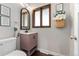Updated bathroom features framed mirror, charming vanity, and a window that offers natural light at 13390 W Warren Ave, Lakewood, CO 80228