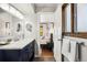 Elegant bathroom features a navy blue vanity, marble countertop and seamlessly connects to a bedroom at 13390 W Warren Ave, Lakewood, CO 80228
