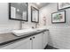 Modern bathroom with dual sinks, white subway tile backsplash, and updated fixtures at 13390 W Warren Ave, Lakewood, CO 80228