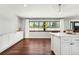 Bright dining room boasts hardwood floors, white cabinets and trim, and large windows with views of the lush yard at 13390 W Warren Ave, Lakewood, CO 80228