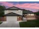 Beautiful home with a well-kept lawn, brick accents, gray siding, and an attached two-car garage at 13390 W Warren Ave, Lakewood, CO 80228
