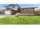 Inviting two-story home featuring a brick facade, well-manicured lawn, and attached two-car garage at 13390 W Warren Ave, Lakewood, CO 80228