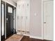 Bright foyer featuring a coat rack with lockers, dark hardwood floors, and stylish front door at 13390 W Warren Ave, Lakewood, CO 80228