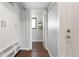 Hallway with hardwood floors leads to light-filled room; built-in storage adds functionality at 13390 W Warren Ave, Lakewood, CO 80228