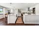 Open-concept kitchen offers two islands, stainless appliances, and stairs leading to another floor at 13390 W Warren Ave, Lakewood, CO 80228