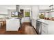 Kitchen with stainless appliances, white cabinets, range, and adjacent breakfast nook with windows at 13390 W Warren Ave, Lakewood, CO 80228