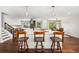 Spacious kitchen featuring a large island with bar stools, stainless steel appliances, and hardwood floors at 13390 W Warren Ave, Lakewood, CO 80228