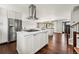 Open kitchen with white cabinets, stainless appliances, and hardwood floors flows into adjacent living spaces at 13390 W Warren Ave, Lakewood, CO 80228