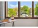 Bright window with clear views of lush landscaping, mature trees, and neighborhood homes at 13390 W Warren Ave, Lakewood, CO 80228