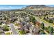 A lovely aerial view showcases a neighborhood with manicured lawns and tree-lined streets near majestic mountains at 6273 Torrey Ln, Arvada, CO 80403