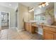 Bathroom featuring wood cabinets, tile floor, large mirror and a glass shower at 6273 Torrey Ln, Arvada, CO 80403