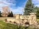 Stone sign welcomes you to Sunrise Ridge, nestled amidst lush greenery and a serene neighborhood at 6273 Torrey Ln, Arvada, CO 80403