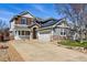 Two-story home with a front porch, attached garage, stone accents, and solar panels on the roof at 6273 Torrey Ln, Arvada, CO 80403