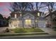 Charming two-story home with a well-manicured lawn and an attached two-car garage at dusk at 6273 Torrey Ln, Arvada, CO 80403