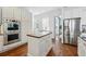 This kitchen boasts stainless steel appliances, white cabinets, and hardwood floors at 6273 Torrey Ln, Arvada, CO 80403