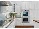 Contemporary kitchen featuring sleek appliances, stylish subway tile, ample cabinet space, and hardwood flooring at 6273 Torrey Ln, Arvada, CO 80403