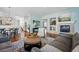 Bright, open-concept living room with a fireplace, hardwood floors, and view of the modern kitchen at 6273 Torrey Ln, Arvada, CO 80403