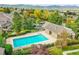 Community pool surrounded by mature trees and landscaping with mountain views at 6273 Torrey Ln, Arvada, CO 80403
