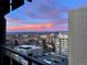 Stunning city view at sunset from balcony of upscale apartment with parking lot and other buildings visible at 790 N Washington St # 1003, Denver, CO 80203