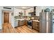 Well-lit kitchen featuring stainless steel appliances, shaker cabinets, wood-look flooring, and tile backsplash at 790 N Washington St # 1003, Denver, CO 80203