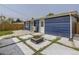 This backyard features a modern fire pit area, concrete pavers, blue siding and well maintained landscaping at 3610 Olive St, Denver, CO 80207