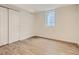 The basement bedroom has wood floors, a small window and a sliding door closet at 3610 Olive St, Denver, CO 80207