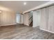 An open basement area with light wood walls and a glimpse of the staircase at 3610 Olive St, Denver, CO 80207