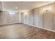 An open basement area with light wood walls and vinyl wood flooring at 3610 Olive St, Denver, CO 80207