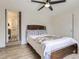 The bedroom features wood-look floors, ceiling fan, a brick accent and access to the bathroom at 3610 Olive St, Denver, CO 80207
